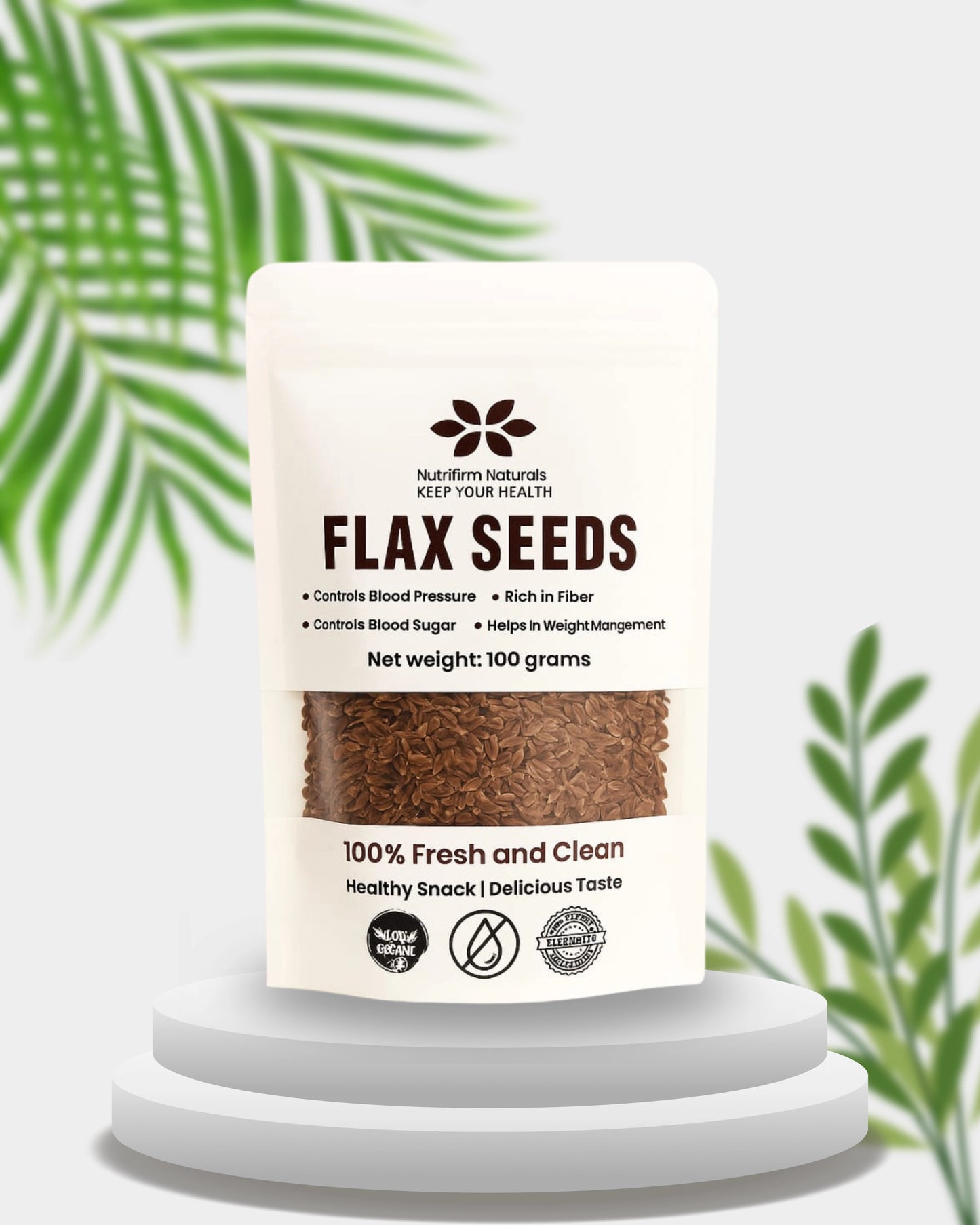 Bottle of flax seeds with a white label on a white background with green leaves.
