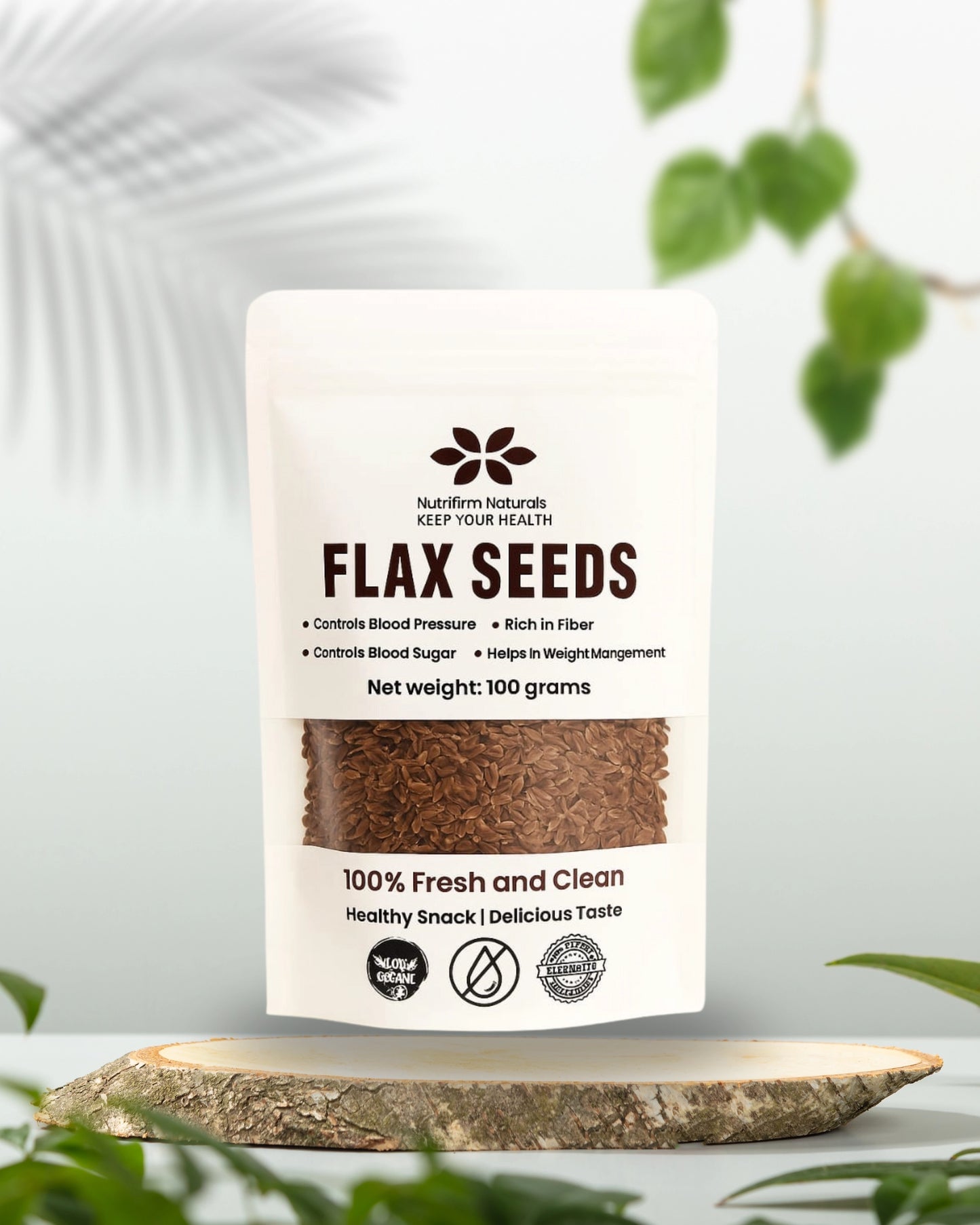 Pouch of flax seeds with a white label on a wooden surface with greenery in the background