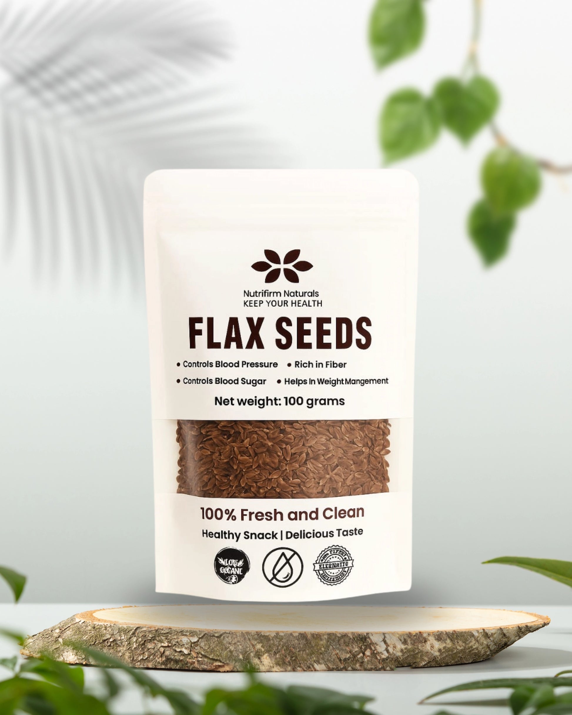 Pouch of flax seeds with a white label on a wooden surface with greenery in the background