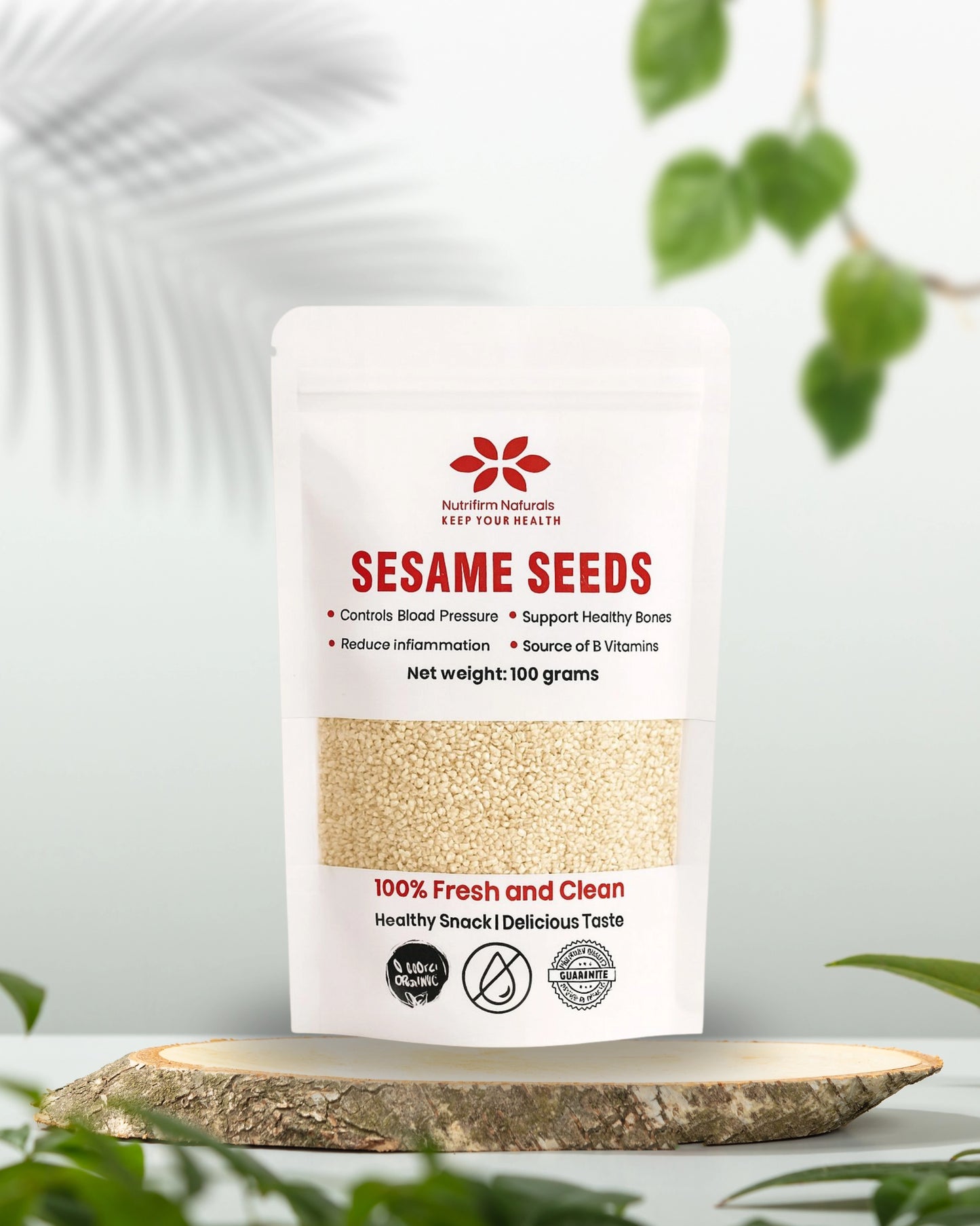 Bag of Nutrifirm Naturals Sesame Seeds on a wooden surface with greenery in the background
