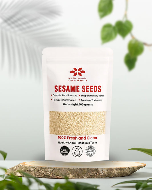 Bag of Nutrifirm Naturals Sesame Seeds on a wooden surface with greenery in the background